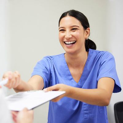 Dental team member handing clipboard to patient