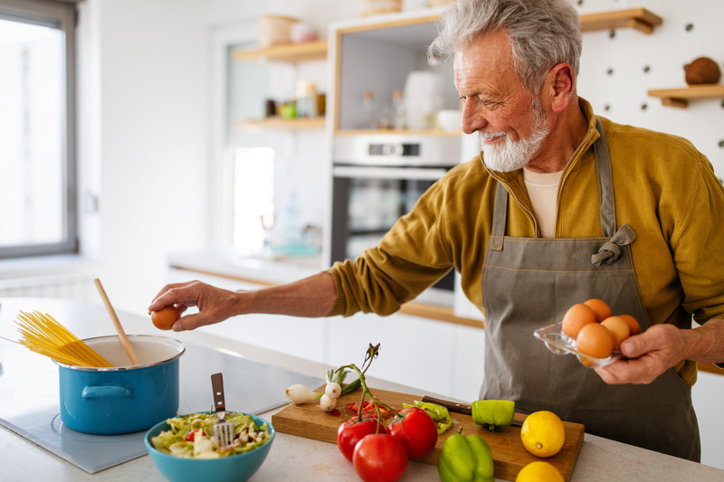 Dental implants patient smiling as they prepare food