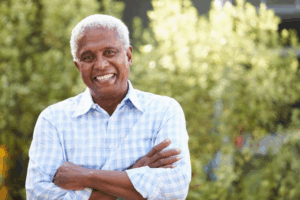 Man smiling with bushes in the background