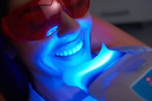Patient getting teeth whitened at dentist’s office.